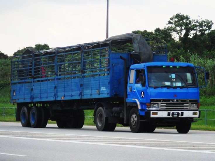 Mitsubishi Fuso Great FP419 Tractor hauling a cargo trailer with timber side wall boards..