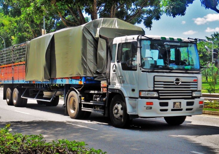 Hino Profia SH Tractor hauling a cargo trailer with timber side wall boards.